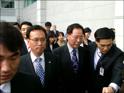 민주노동당 문성현 대표와 권영길 의원이 경호원의 호위를 받으며 공항 기자회견실로 빠져나가고 있다. 